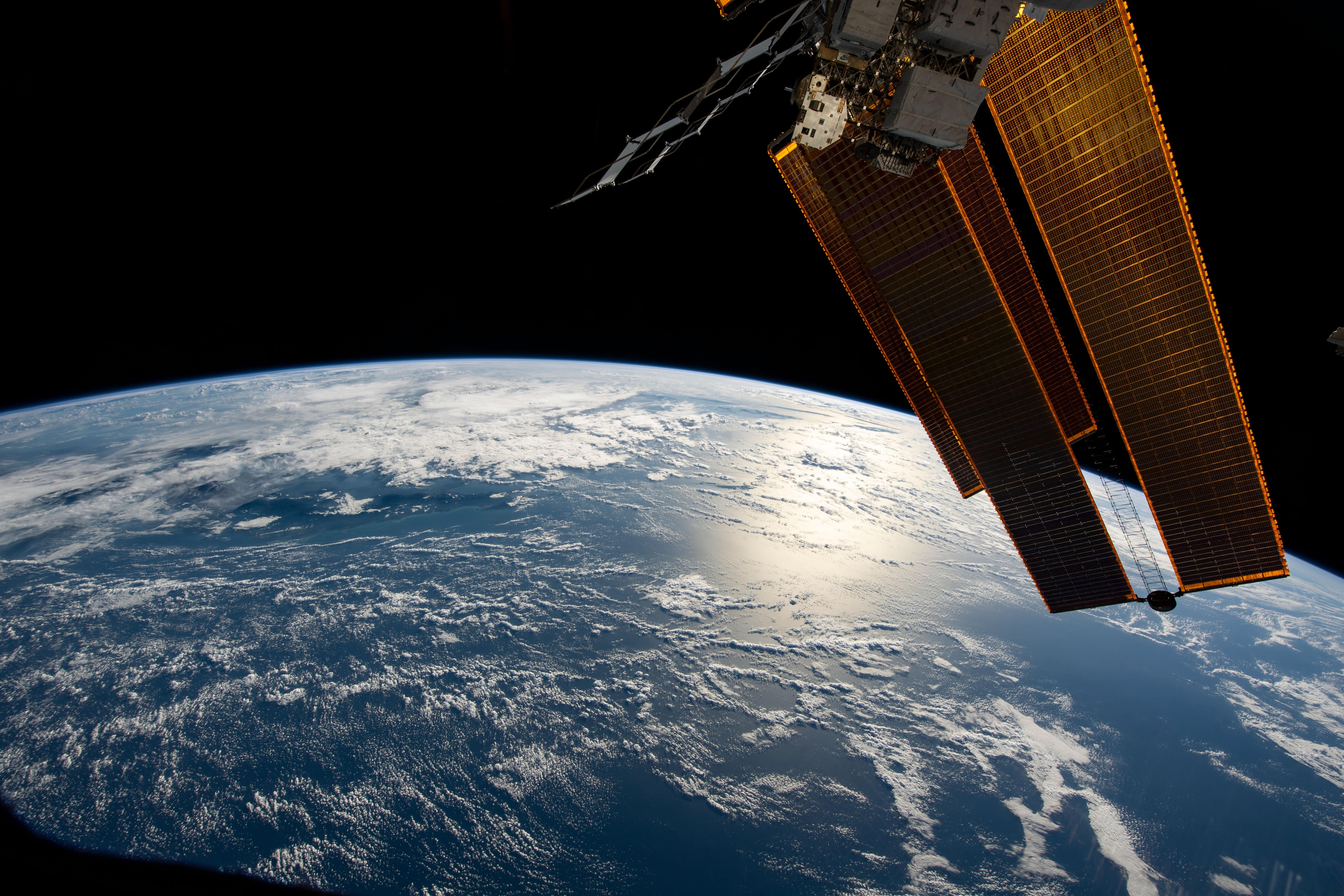 View of the Earth taken from the ISS, with part of the ISS in the image.